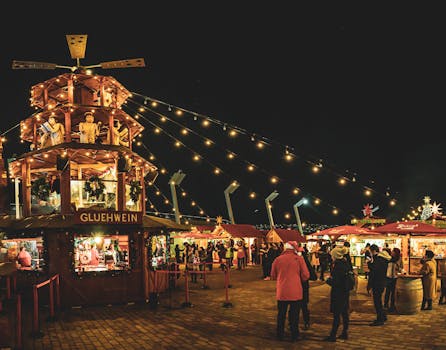 Lively night scene at a Christmas market with lights and Glühwein stall.